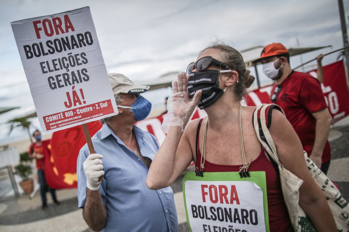 A demonstrator holds a sign that reads "Go Away Bolsonaro, General elections now!" during a rally against President Jair Bolsonaro and Governor of Rio de Janeiro Wilson Witzel amidst the coronavirus (COVID-19) pandemic at Copacabana beach on June 28, 2020 in Rio de Janeiro, Brazil.