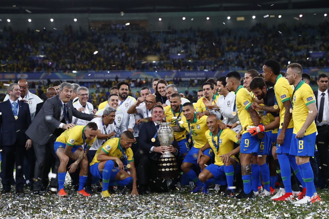  President of Brazil Jair Bolsonaro celebrates with the trophy and the players of Brazil after winning the Copa America final against Peru.