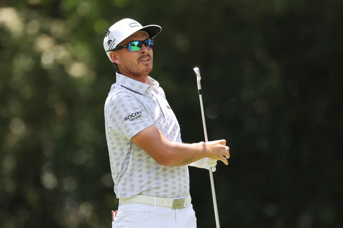 Rickie Fowler uses a golf club to remove a snake at the Wells Fargo Championship.