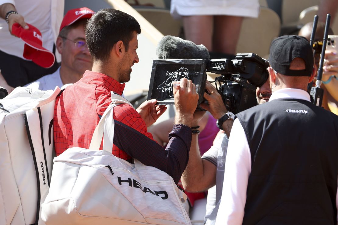 Djokovic writes a message on a TV camera lens at Roland-Garros. 