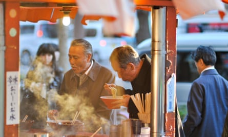 Salarymen in Japan eating a bowl of noodles.