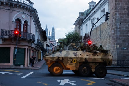 Soldiers in an armoured vehicle patrol Quito’s historic centre after the outbreak of violence