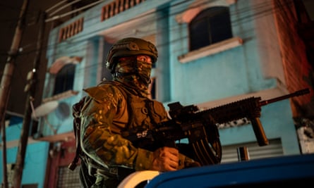 A soldier keeps watch from a pick-up truck during a search for suspects during curfew in Guayaquil on 12 January.