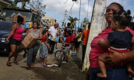 Residents gather and receive food and water, provided by FEMA, in a neighbourhood without grid electricity or running water on 17 October 2017 in San Isidro, Puerto Rico.