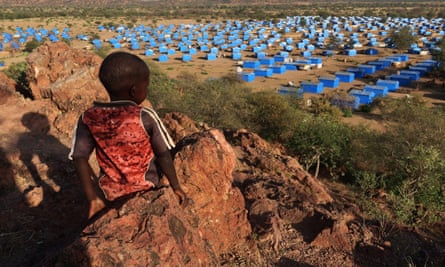 A boy overlooks a refugee camp near the Chad-Sudan border