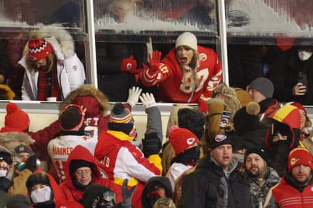 swift high fives people as she leans out from box seat