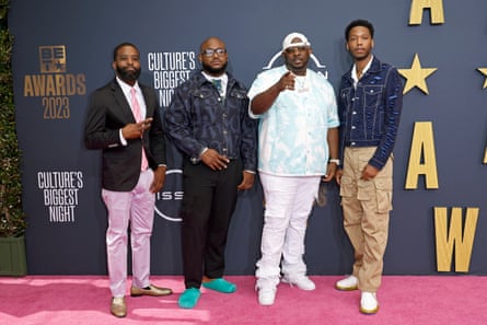 four men pose on red carpet