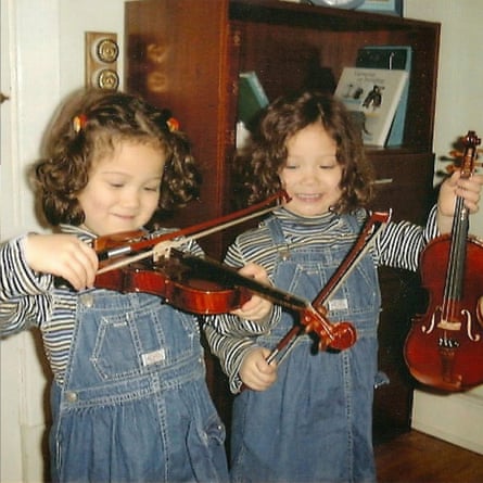 Laufey and her twin sister as children, playing violinis