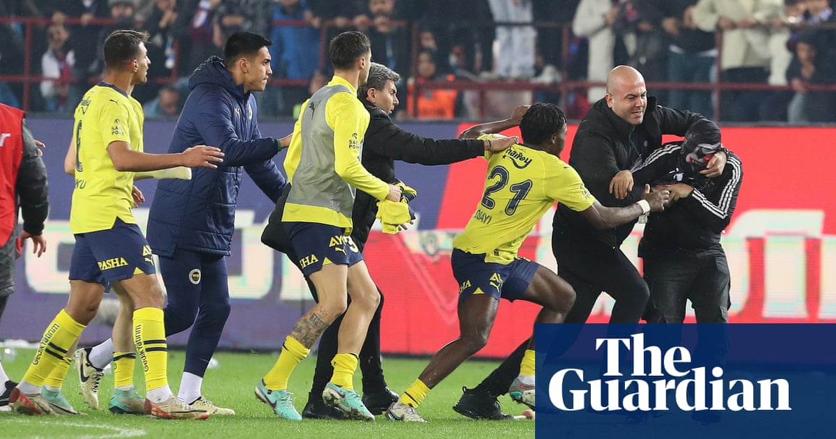 Trabzonspor supporters enter the field and engage in physical altercations with Fenerbahce players following their loss.