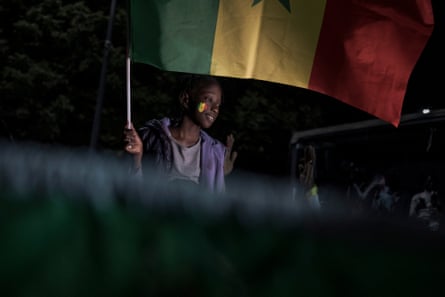 A child holds up a Senegalese flag in celebration of the presumed win of Bassirou Diomaye Faye in Senegal’s presidential elections