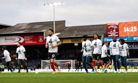 Luton’s players warm up wearing T-shirts honouring Tom Lockyer before the match against Newcastle
