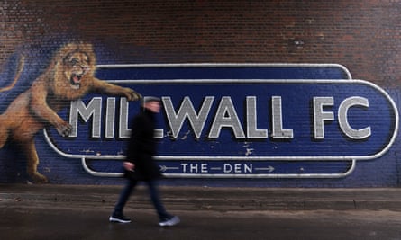 A fan walks past a Millwall sign on their way to the Den for an FA Cup tie.