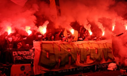 Celtic fans set off flares behind a banner reading: “Champions”