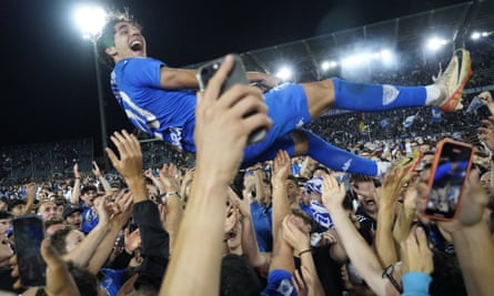 Matteo Cancellieri is thrown in the air by Empoli supporters in wild celebrations on the pitch.