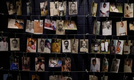 Rows of photographs pegged on to strings, showing portraits and family photos of victims