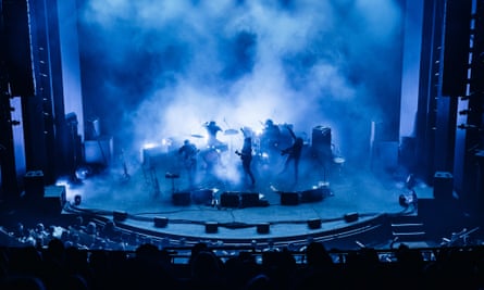 Musicians performing on a blue-lit stage