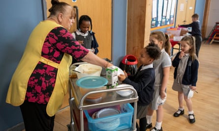 Pupils line up for porridge at The Priory Primary School in Wednesbury, West Midlands.