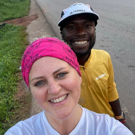 A ‘selfie’ portrait of an African man and a white woman beside a road, both smiling