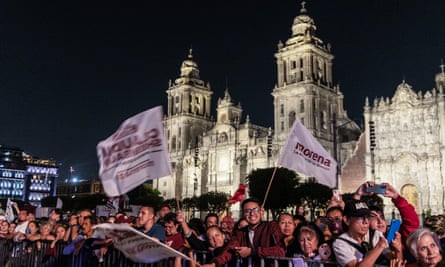 A crowd cheering and waving at Zocalo Square in Mexico City