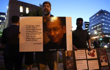 A man in Washington DC holds a picture of the late Chinese dissident Liu Xiaobo during a candlelight vigil to mark the anniversary of the Tiananmen Square massacre