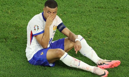 France’s Kylian Mbappé holds his nose after an accidental collision with Austria’s Kevin Danso