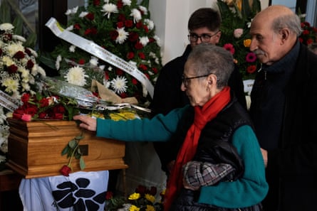 A woman places a rose on Amelia Sanjurjo’s coffin