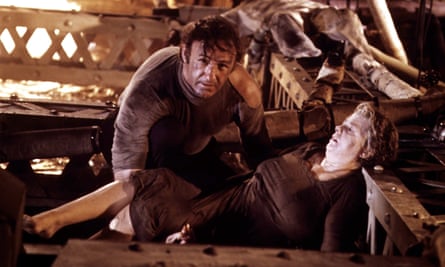 film still of man and woman amid burning debris