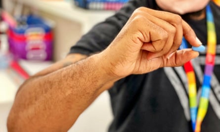 A man holds a blue pill between his finger and thumb