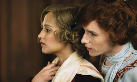 Alicia Vikander with Eddie Redmayne looking over he shoulder, both in period costume. 