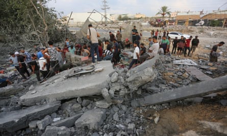 People standing amid the rubble of a destroyed building. 