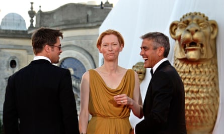 Brad Pitt and George Clooney share a joke as Tilda Swinton looks to the camera