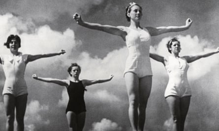 A black and white image of women in swimming costumes with their arms outstretched