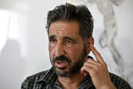 Ashraf al-Muhtaseb, 53, from Hebron, a musician points to his ear