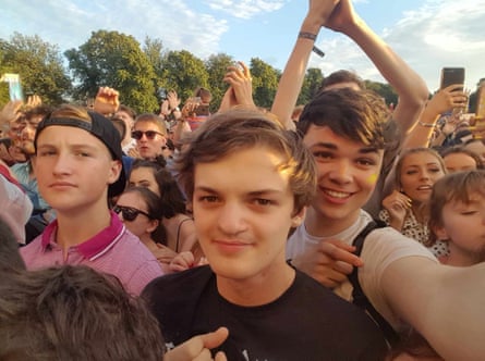 Selfie of friends amid crowd at a festival.