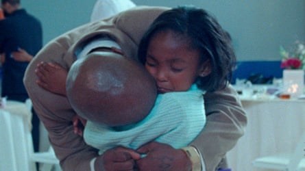 A father hugs his young child.