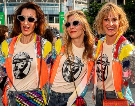 Three women in sequined jackets and Sex Pistols-referencing Taylor Swift T-shirts reading ‘God Save the Queen’