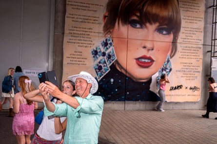 Fans take a selfie in front of a poster at Wembley