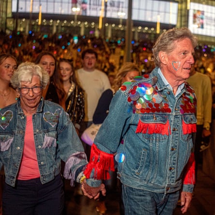 An older man and woman walking up to Wembley in customised sequined and tasselled denim jackets