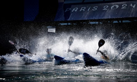 Competitors in the women’s kayak cross event splash into the water off the ramp at the start of their in the quarter-final at the Vaires-Sur-Marne Nautical Stadium