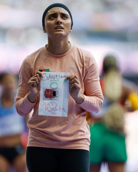 Sprinter Kimia Yousofi of Afghanistan displays a message on the back of her name badge saying “Education, Sport, Our Rights” after competing in her 100m preliminary round