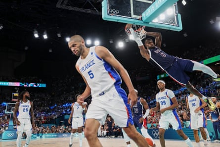 LeBron James of the United States hangs off the rim after dunking against France during the men’s basketball gold medal game