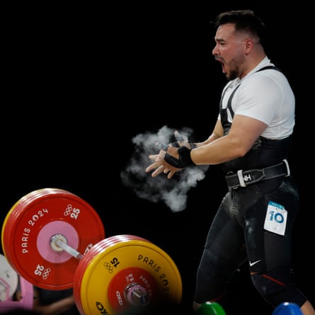 Ramiro Mora Romero of the Refugee Team, who lives and trains in Britain, celebrates with the crowd after successfully completing his final lift in the clean and jerk of the weightlifting men’s 102 kg competition