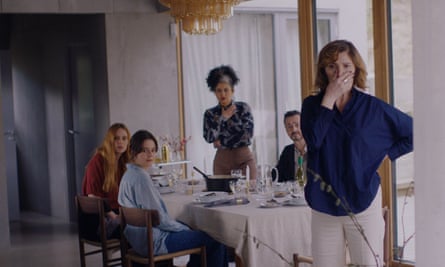 five people at lunch, two of them standing looking shocked at something 