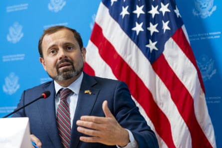 A man in front of a flag