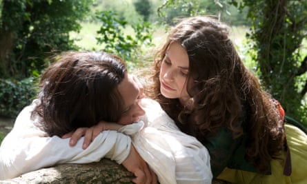 Cathy stares into Heathcliff’s eyes as he rests his head on a fence