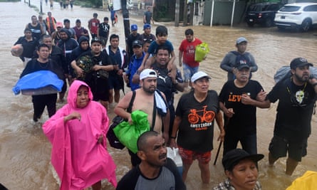 Dozens of couple in brown ankle-deep water.