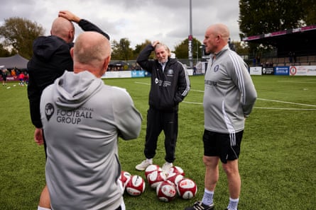 Talking to his coaching staff on the pitch as the teams warm up before kick off.