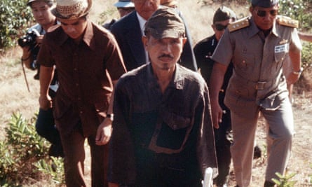 Hiroo Onoda accompanied by members of the press and military officials.