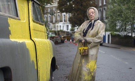 Maggie Smith with a paint can painting a grey van yellow