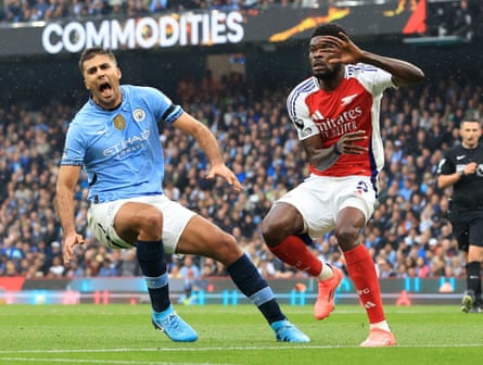 Rodri is injured as Arsenal’s Thomas Partey watches on.